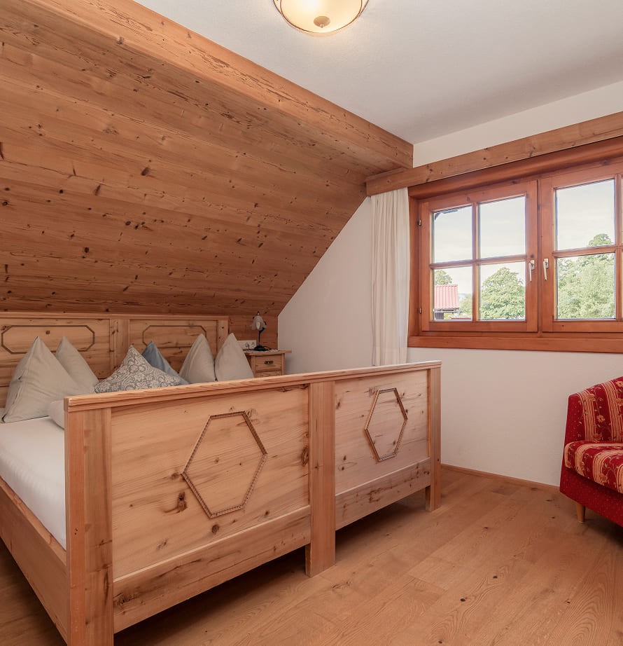 Schlafzimmer mit handgefertigtem Holzbett im Chalet