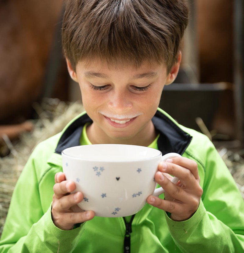 Kind genie&szlig;t frische Milch vom Bio-Bauernhof Feichtlhof
